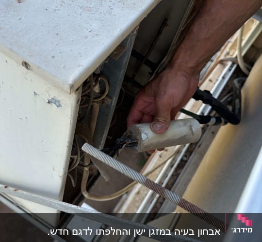 יד מחזיקה חלק ממזגן חיצוני
